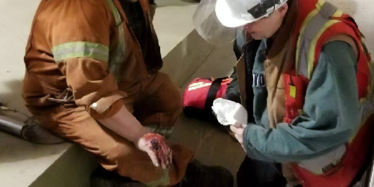 First aid instructor demonstrating wound care and dressing on worksite